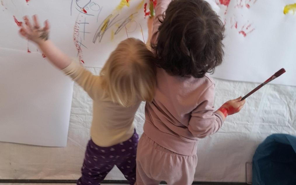 2 Kleinkinder beim Malen an einer Leinwand im Kunstmuseum