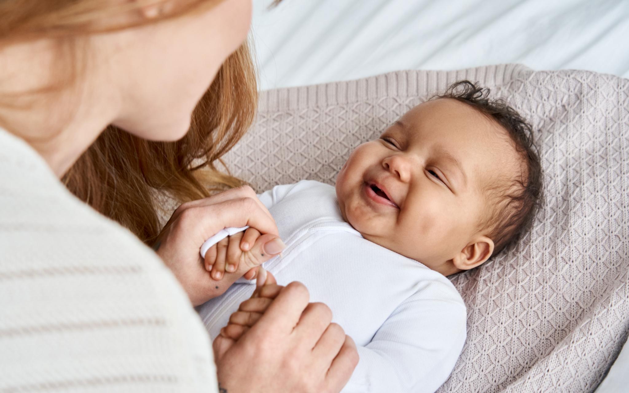 Eine Mutter schaut ihr Baby an, das Baby lacht.