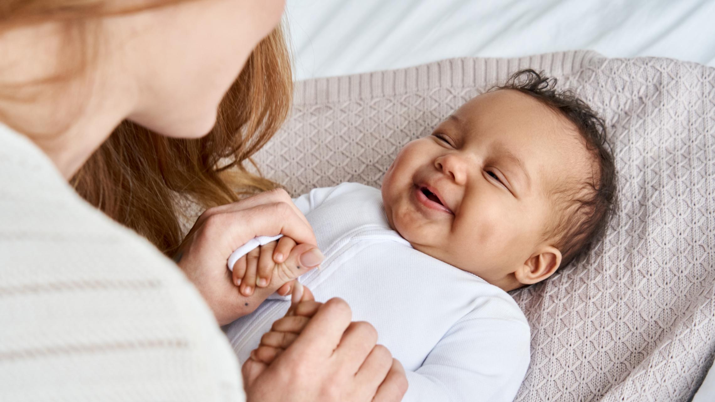 Eine Mutter schaut ihr Baby an, das Baby lacht.