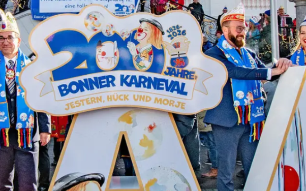 Foto mit OB Dèus, dem Karnevalsmotto 2026 'Jestern, Hück und morje' und zwei Karnevalisten aus Bonn
