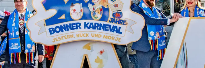 Foto mit OB Dèus, dem Karnevalsmotto 2026 'Jestern, Hück und morje' und zwei Karnevalisten aus Bonn