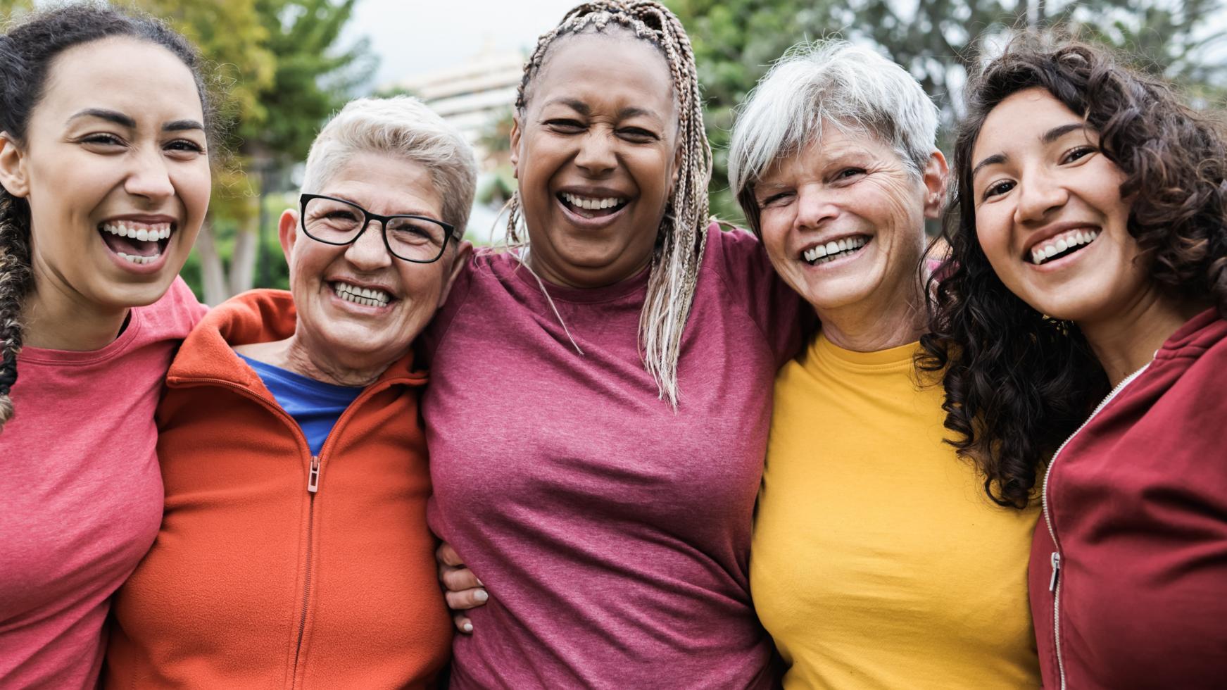 Foto mit 4 fröhlichen Frauen, die eng beisammen stehen und sich umarmen