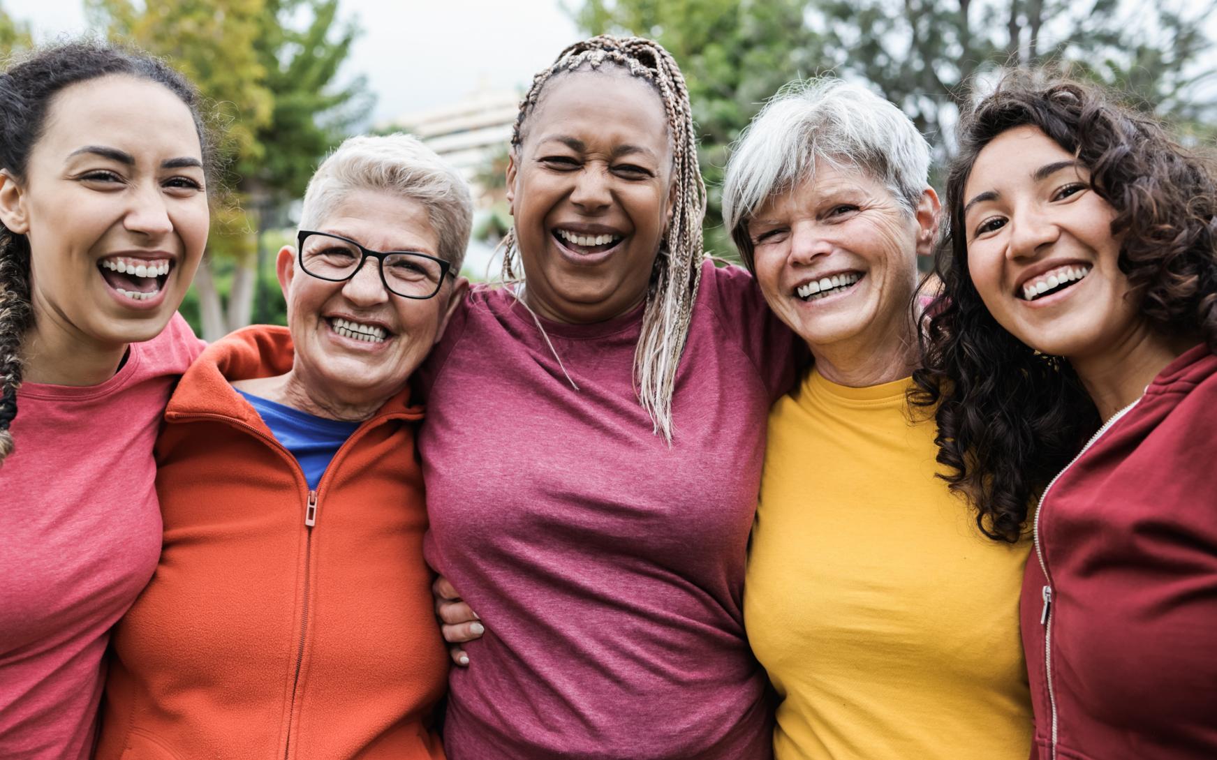 Foto mit 4 fröhlichen Frauen, die eng beisammen stehen und sich umarmen