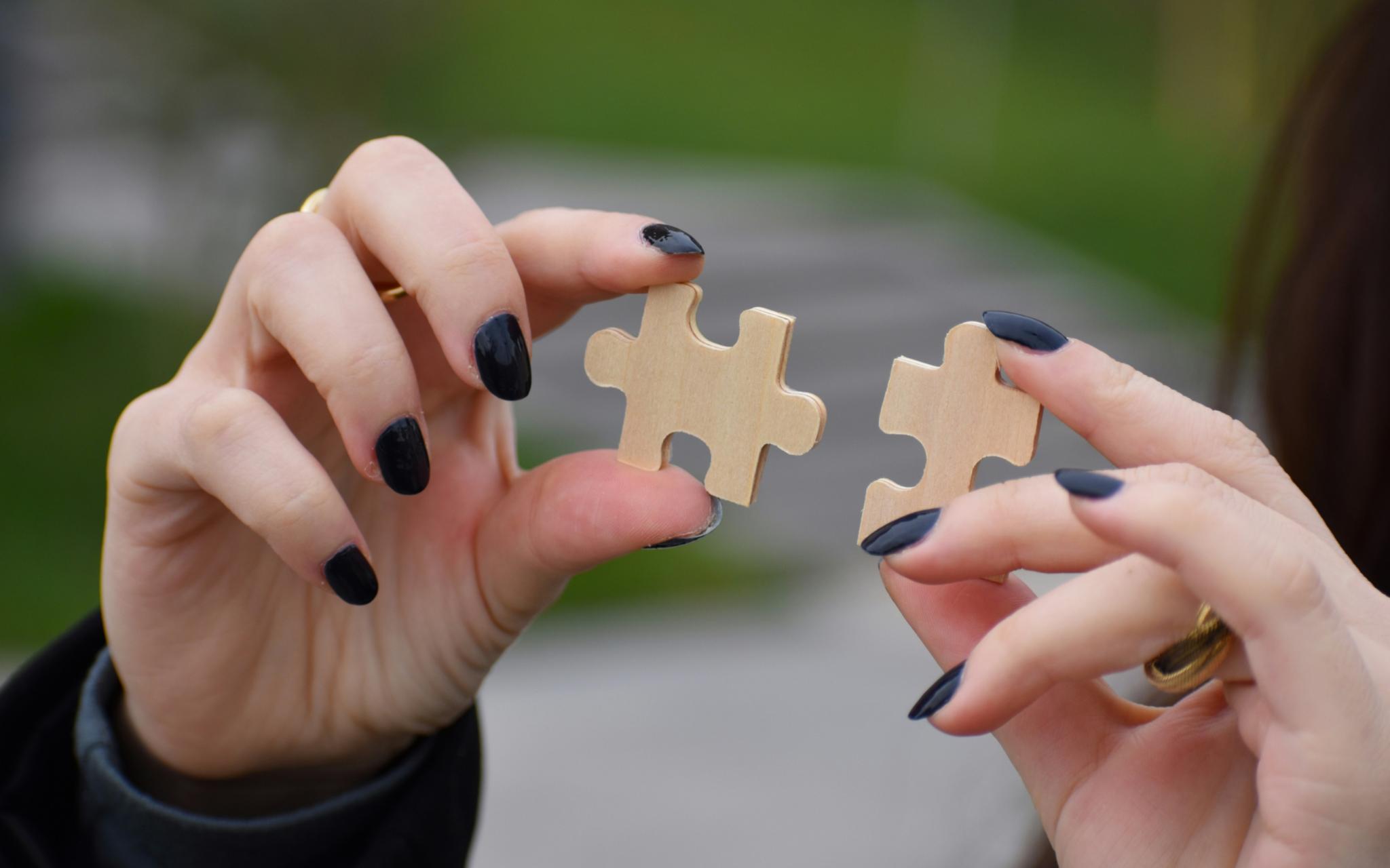 Hände mit Puzzleteilen