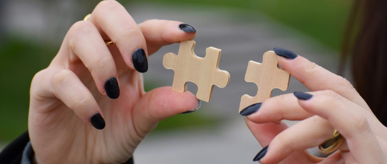 Hände mit Puzzleteilen