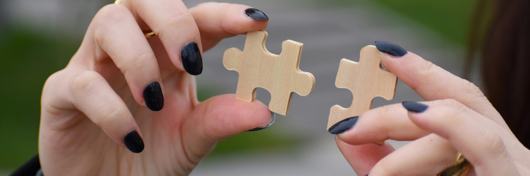 Hände mit Puzzleteilen
