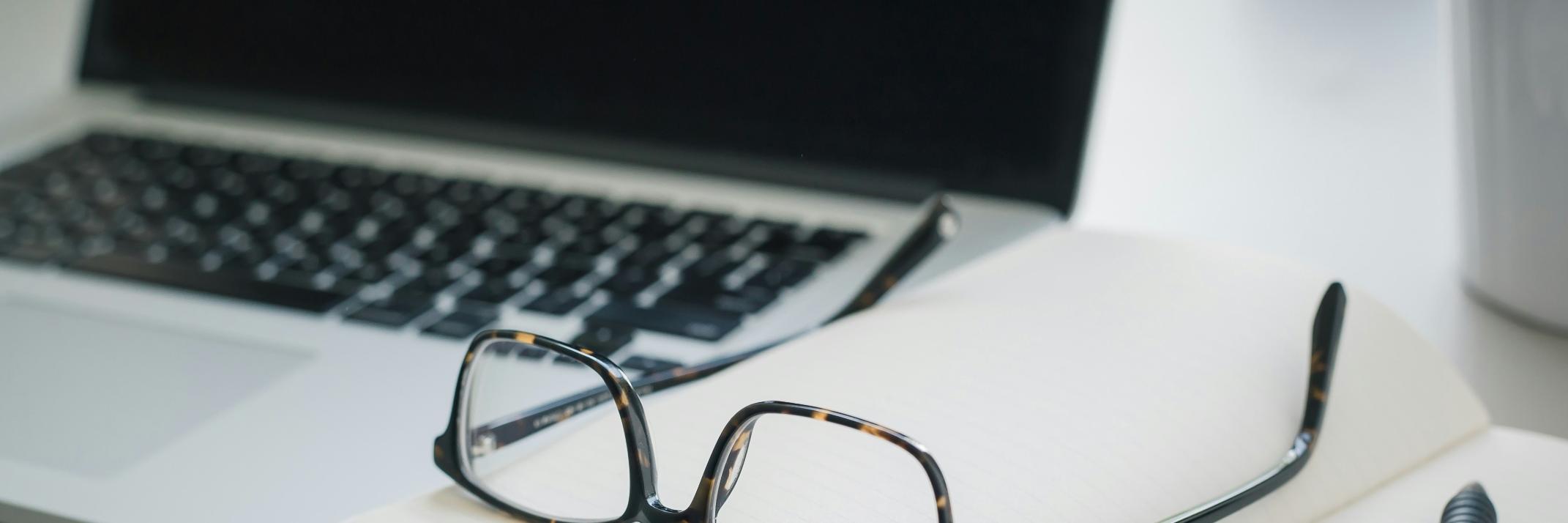 Arbeitsbrille, die auf Dokumenten liegt