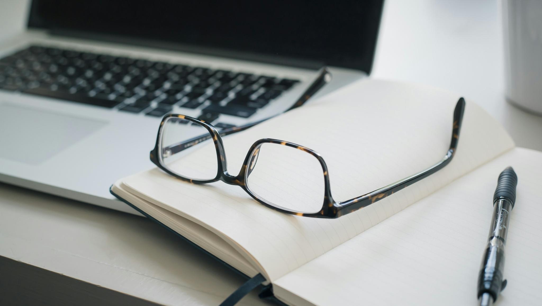 Arbeitsbrille, die auf Dokumenten liegt