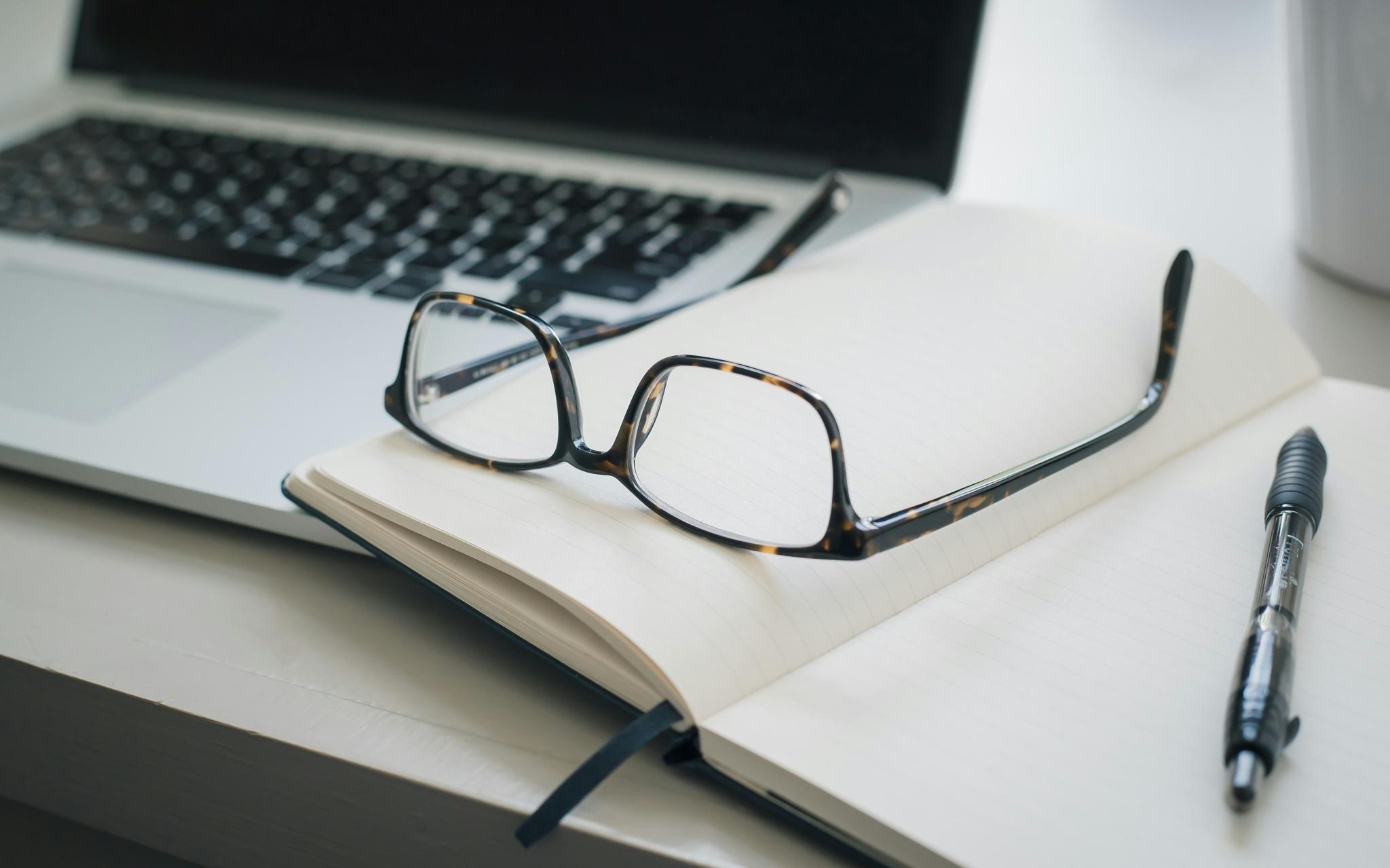 Arbeitsbrille, die auf Dokumenten liegt