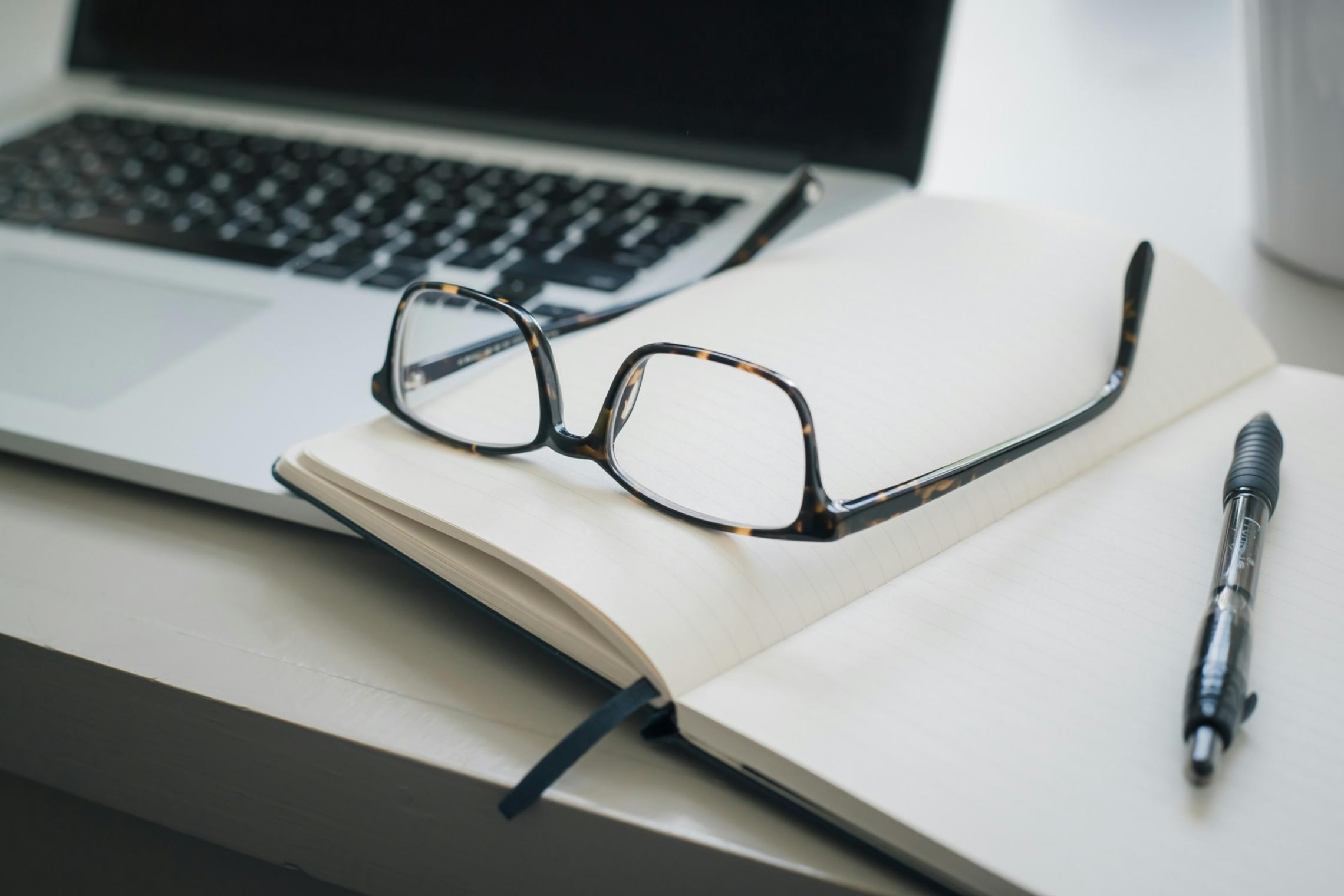 Arbeitsbrille, die auf Dokumenten liegt